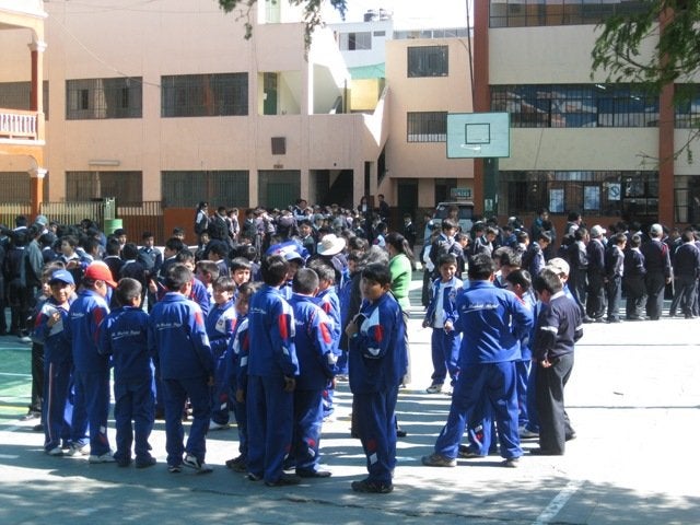 ¿Tus alumnos saben por dónde escapar? Guía completa de señales de evacuación escolar 2025. 3 Estudiantes en Arequipa observando señales de evacuación en el colegio durante un simulacro