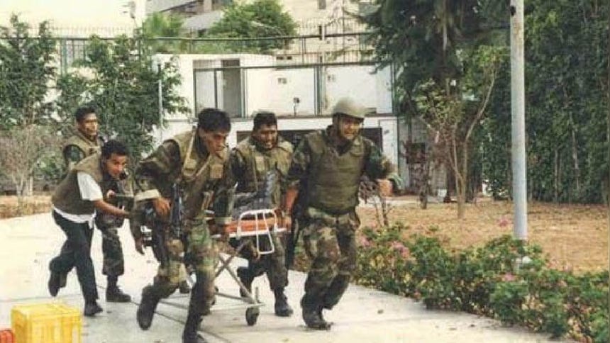 Los comandos sacan de la embajada a un compañero de armas herido. 