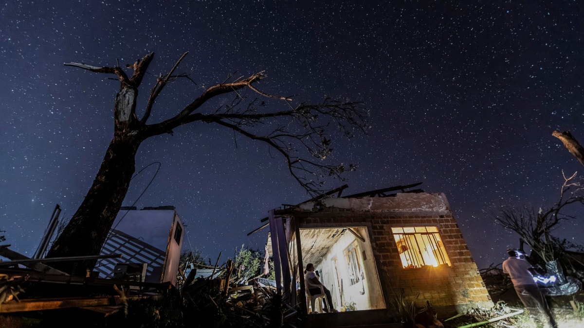 Una mujer espera sentada en su casa el último sábado, parcialmente destruida por un tornado en Rio Bonito do Iguaçu (Brasil).