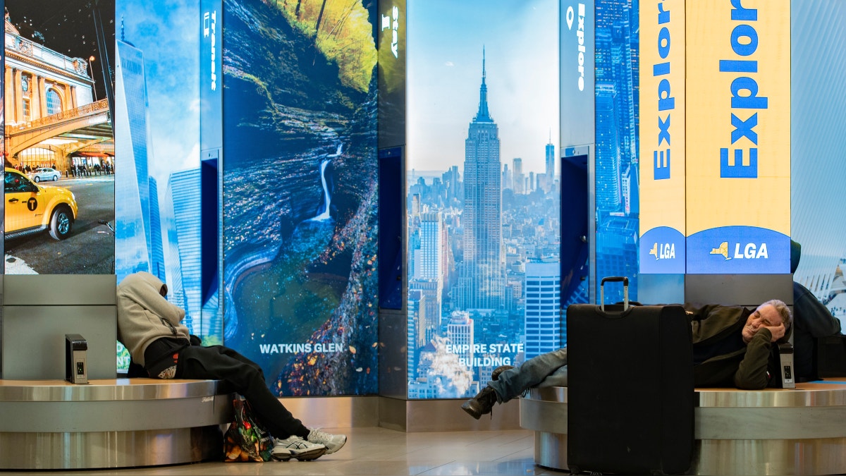 Personas duermen en los pasillos del aeropuerto La Guardia, en Nueva York (EE.UU.), en medio de la cancelación de miles de vuelos. 
