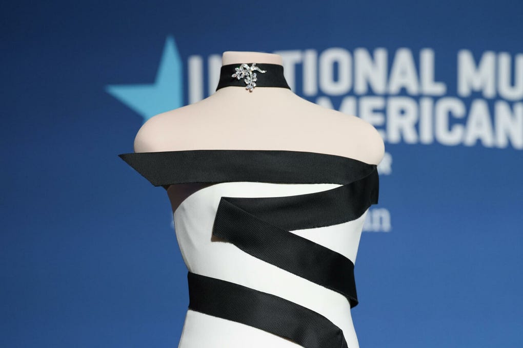 El traje sin tirantes de crepé de seda marfil, rematado con gazar de seda negra, fue diseñado por el franco-estadounidense <strong>Hervé Pierre</strong>.