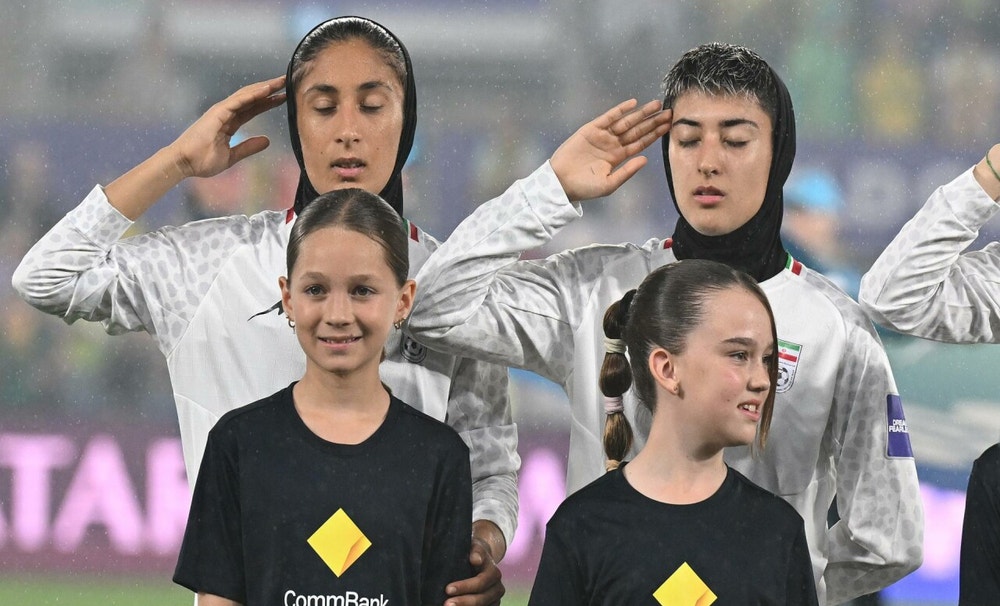 Con una mano en la cabeza en un gesto similar a un saludo militar, las deportistas entonaron el Himno Nacional iraní, mientras se escuchaba algún abucheo y silbido desde la grada, según reportó la agencia EFE.