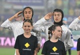 Con una mano en la cabeza en un gesto similar a un saludo militar, las deportistas entonaron el Himno Nacional iraní, mientras se escuchaba algún abucheo y silbido desde la grada, según reportó la agencia EFE.