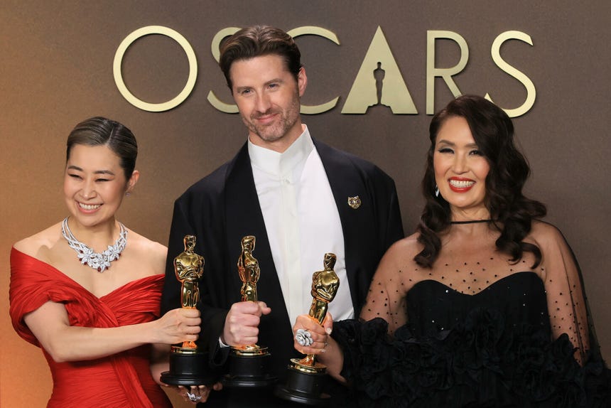 Maggie Kang, Chris Appelhans y Michelle L. M. Wong posan con el Oscar por 'Las guerreras K-pop'.