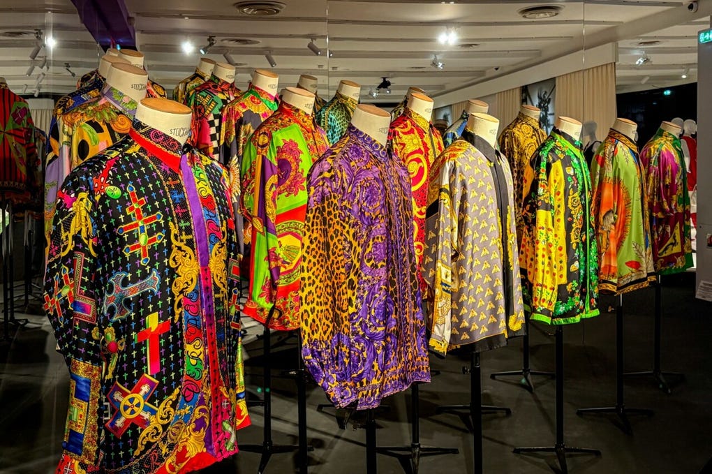 El recorrido expositivo, concebido como un “hilo rojo” que sigue la vida y trayectoria de Versace, según explica Barreneche, incluye secciones como Magna Grecia, dedicada a las influencias del mundo clásico mediterráneo en sus creaciones, y Barocco, que explora la estética exuberante y opulenta que terminó convirtiéndose en uno de los sellos distintivos de la firma.