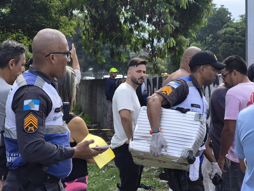 Un policía militar recupera una maleta entre los escombros dejados por la colisión de dos helicópteros en Recreio dos Bandeirantes, Río de Janeiro, accidente que dejó seis personas fallecidas.