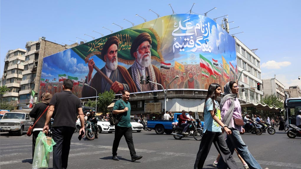  Ciudadanos iraníes pasan junto a una gran valla publicitaria con la imagen del difunto líder supremo iraní, el ayatolá Ruhollah Khomeini, y del líder supremo, el ayatolá Ali Khamenei, en una calle de Teherán