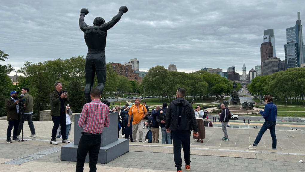 Foto que muestra a personas observando la estatua de Rocky Balboa ubicada en las escaleras del Museo de Arte de Filadelfia, Pensilvania (EE.UU.).