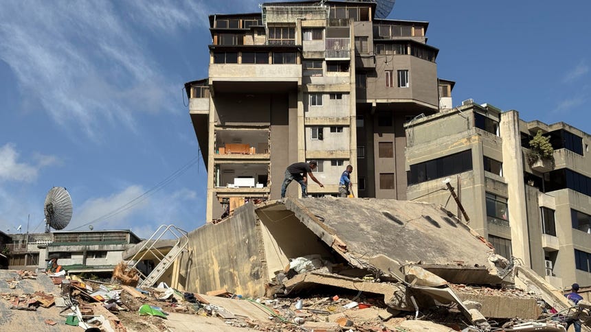  Personas ayudan a remover escombros de edificios derrumbados por los terremotos este jueves, en el sector San Bernardino, en Caracas (Venezuela).