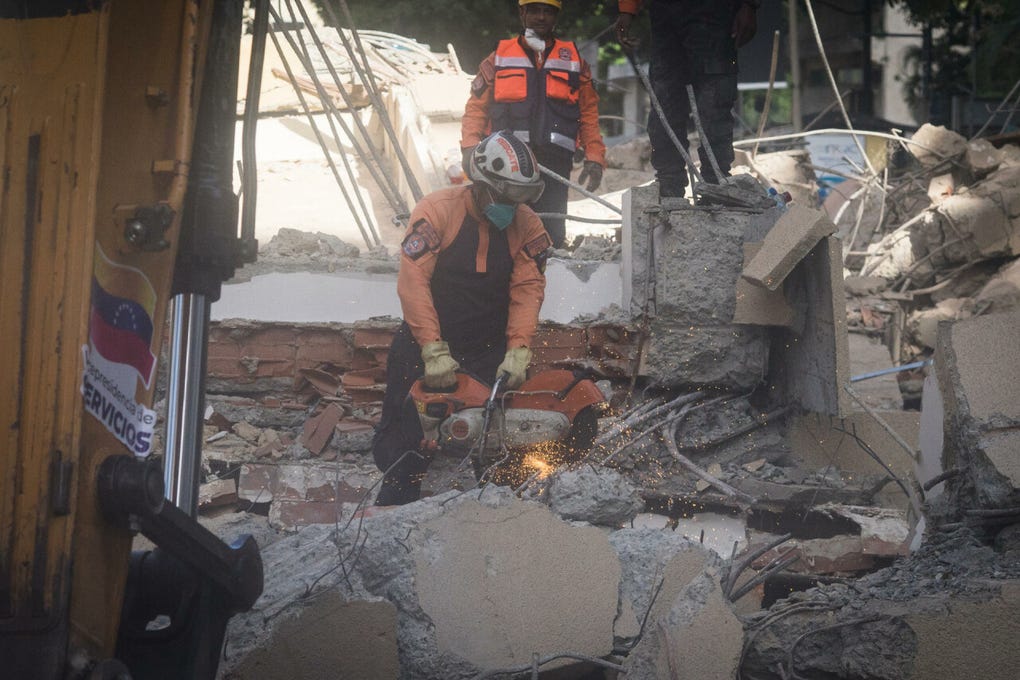 En Altamira, el polvo se levantaba mientras funcionarios de Protección Civil y el Ministerio de Obras Públicas se encargaban de la remoción escombros de dos edificios que colapsaron por completo y bloquearon el paso de una avenida.