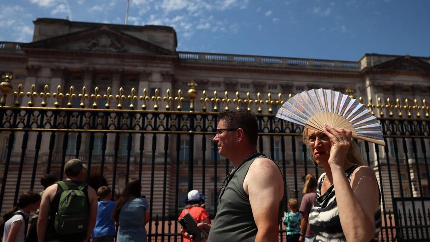 Una mujer se protege la cabeza del sol mientras camina frente al Palacio de Buckingham durante una ola de calor en Londres, Gran Bretaña, el 26 de junio de 2026. La alerta roja por calor extremo emitida por la Met Office sigue vigente para el este y el sureste de Inglaterra, mientras una ola de calor continúa azotando gran parte del Reino Unido.