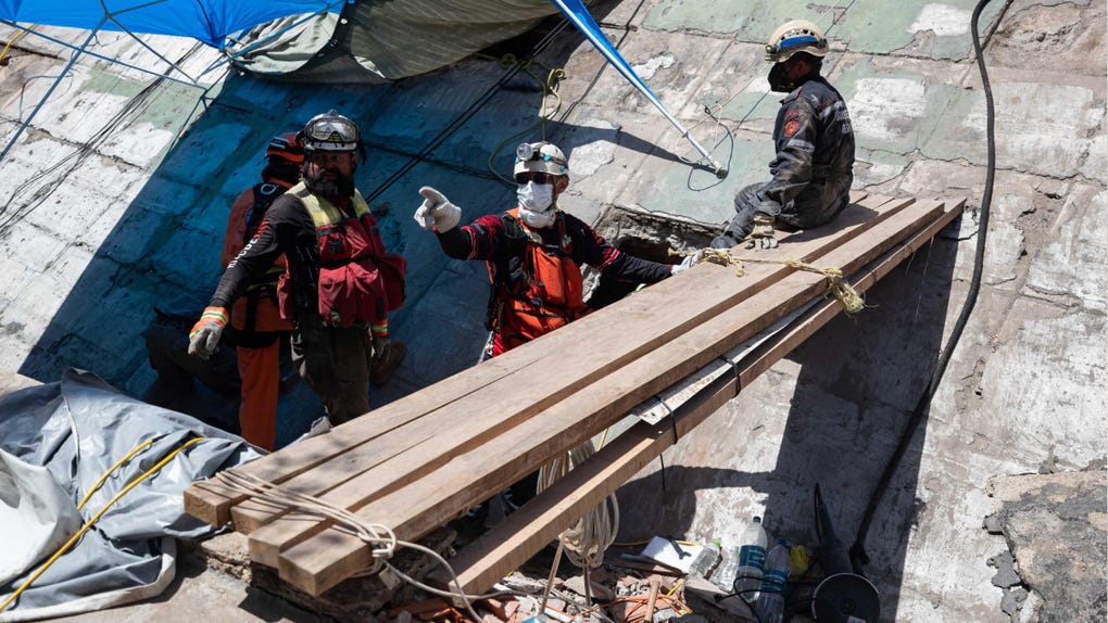 Rescatistas realizan labores de búsqueda en un edificio afectado por los terremotos.