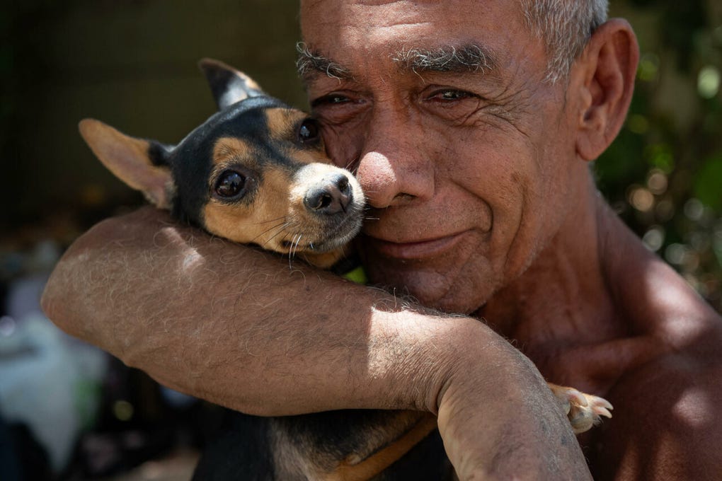 Un hombre abraza a su perro rescatado de los escombros de un edificio afectado por los terremotos, este miércoles, en La Guaira (Venezuela).