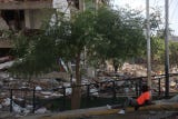 Una persona descansa frente a escombros de edificios afectados por el terremoto de magnitudes 7,2 y 7,5, este miércoles, en La Guaira (Venezuela).