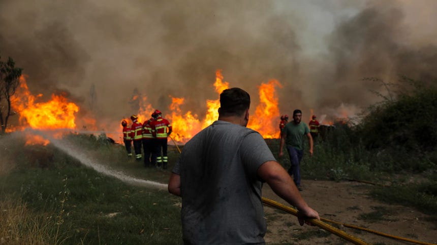 Los bomberos y los residentes locales luchan contra el incendio forestal de Vouzela en Cercosa, una parroquia del municipio de Mortagua, Portugal, el 4 de julio de 2026. 