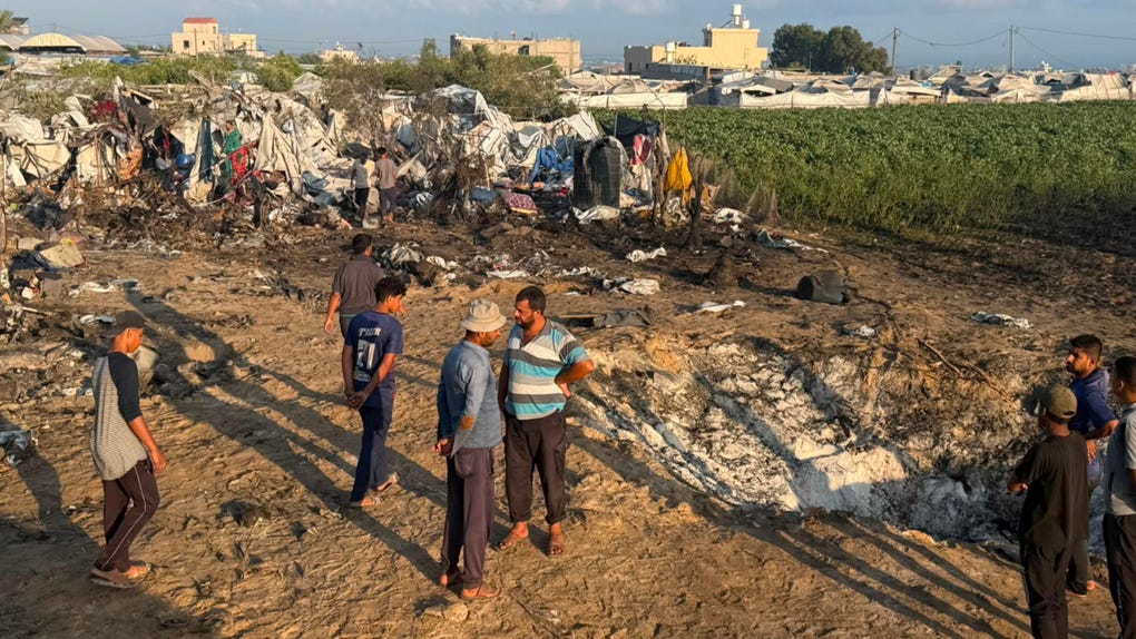 Varios hombres permanecen sobre los restos del campamento donde residen desplazados tras un bombardeo en Jan Yunis (sur de Gaza) en el que murieron asesinados una bebé de un año y a su madre y destruyó al menos un centenar de tiendas de campaña.