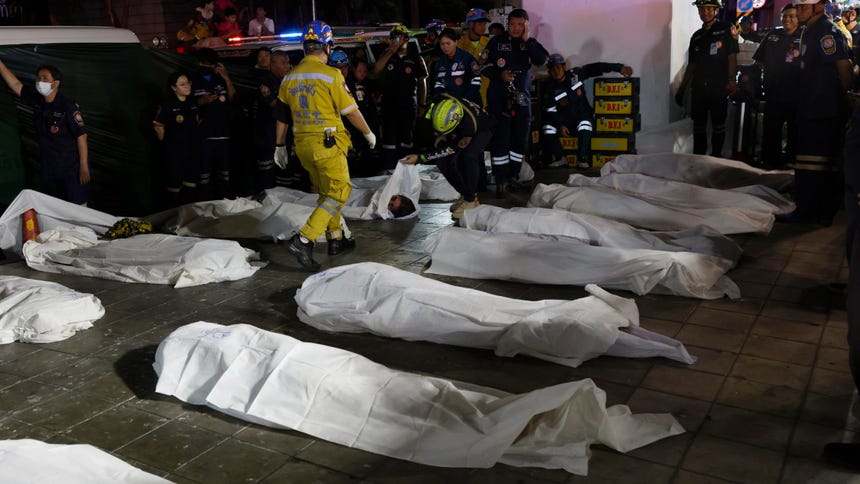 Rescatistas recuperan el cuerpo de las víctimas del incendio en el bar en Bangkok.
