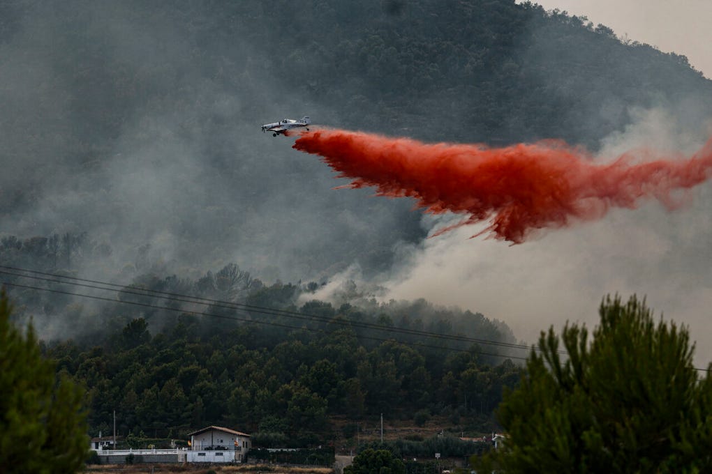 Un avión realiza una descarga con retardante en Betxí en el frente del incendio declarado este sábado en la Vall dUixó (Castellón), y que lleva quemadas ya unas 4 300 hectáreas y cuyo perímetro supera los 40 kilómetros