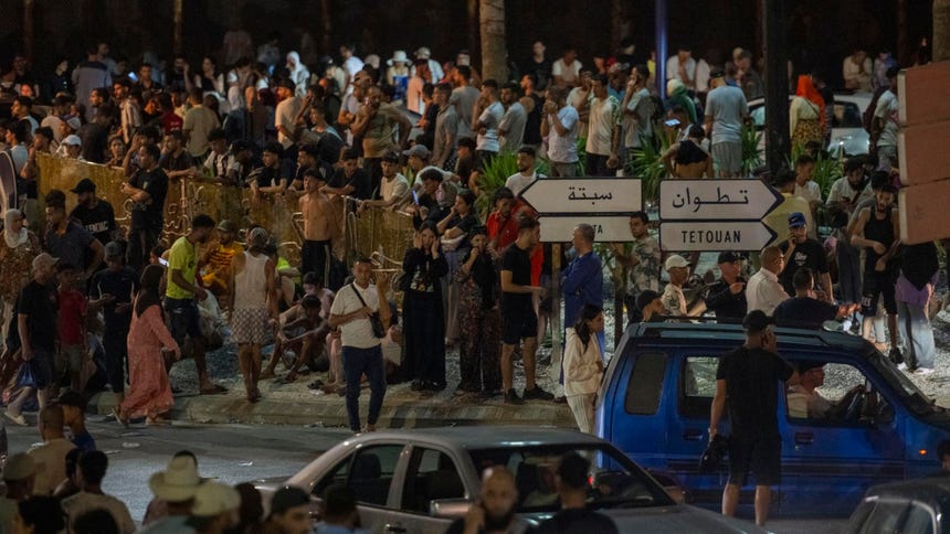 Varias personas se concentran en el paso fronterizo de Bab Sebta, entre Marruecos y el enclave español de Ceuta, cerca de Fnideq (Marruecos), el 30 de julio de 2026. España y Marruecos acordaron la repatriación urgente de los migrantes que habían entrado de forma irregular en territorio español, según el Ministerio del Interior español.