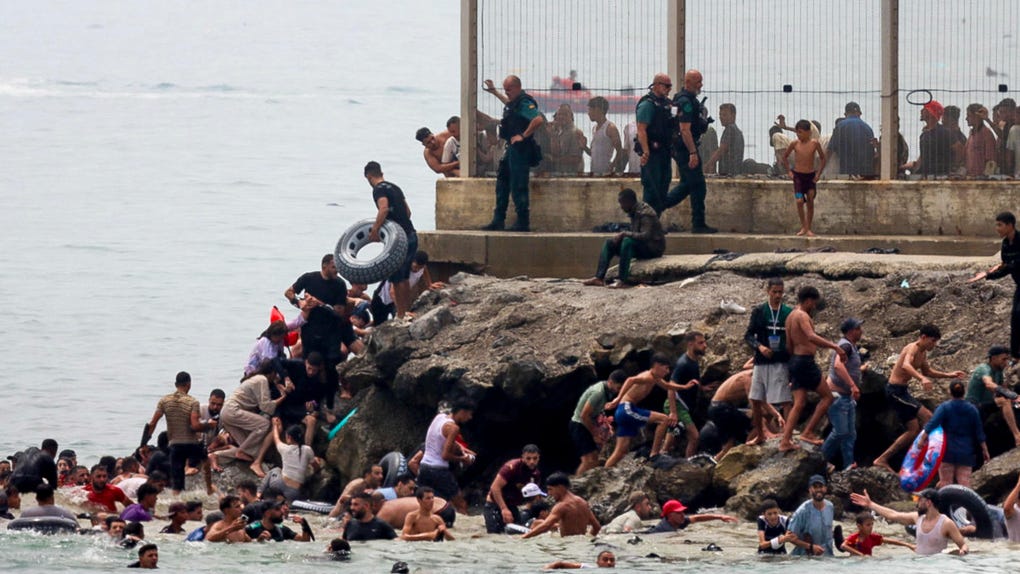Miles de jóvenes marroquíes tratan de cruzar la valla fronteriza con Ceuta