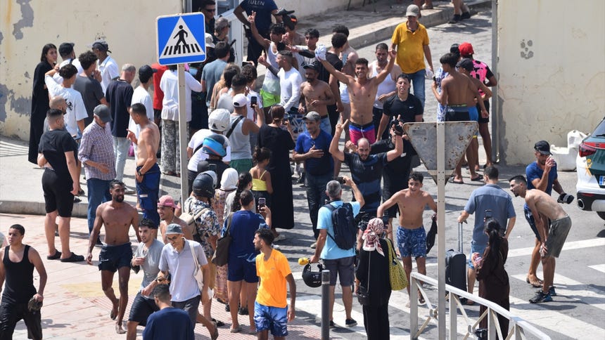 Varios migrantes celebran haber cruzado la frontera, a 30 de julio de 2026, en Ceuta (España).