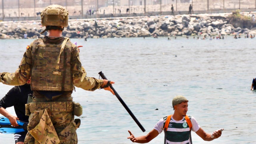 Varios migrantes llegan a la costa española de Ceuta, este viernes. Las fuerzas de seguridad y los servicios de emergencia siguen localizando algunos cuerpos de las miles de personas, sobre todo marroquíes y argelinos, que se lanzaron al mar desde las costas marroquíes de Castillejos para intentar alcanzar la costa ceutí a nado en los últimos días; y no se descarta que la cifra continúe aumentando. 