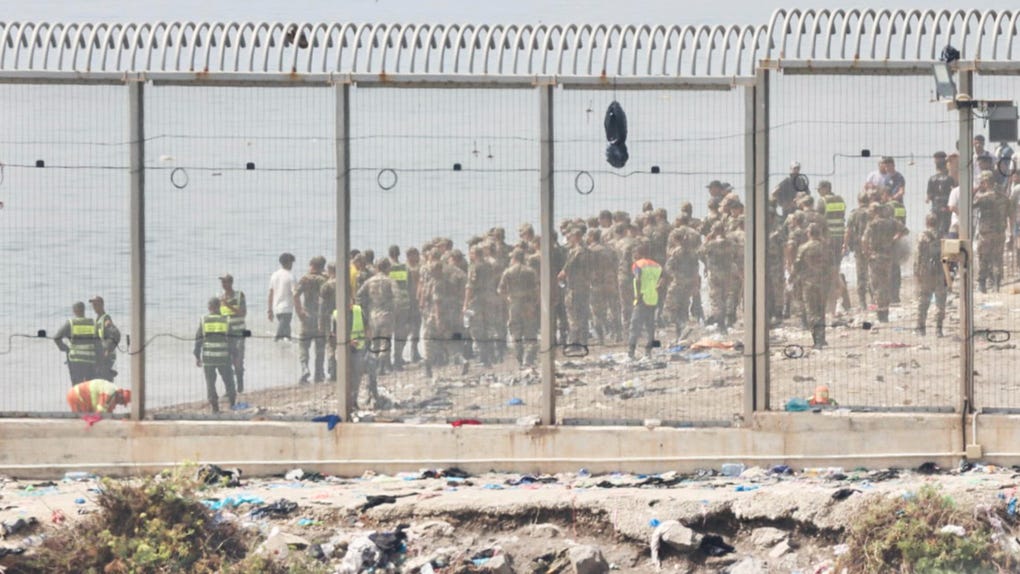 Fuerzas auxiliares de Marruecos impiden la llegada al espigón de la playa del Tarajal que separa Ceuta de Marruecos.