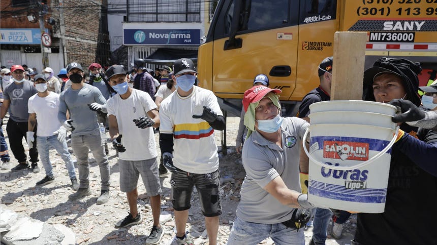 Voluntarios retiran escombros de un edificio tras el terremoto de magnitud 7,4 que sacudió la mayor parte de Colombia, este martes en el sector de La Lorena en Pereira (Colombia). 