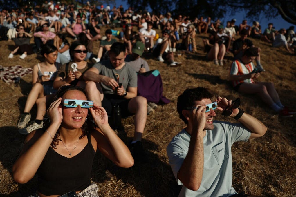 Una espectadora observa el eclipse utilizando protección especial para cuidar su vista.