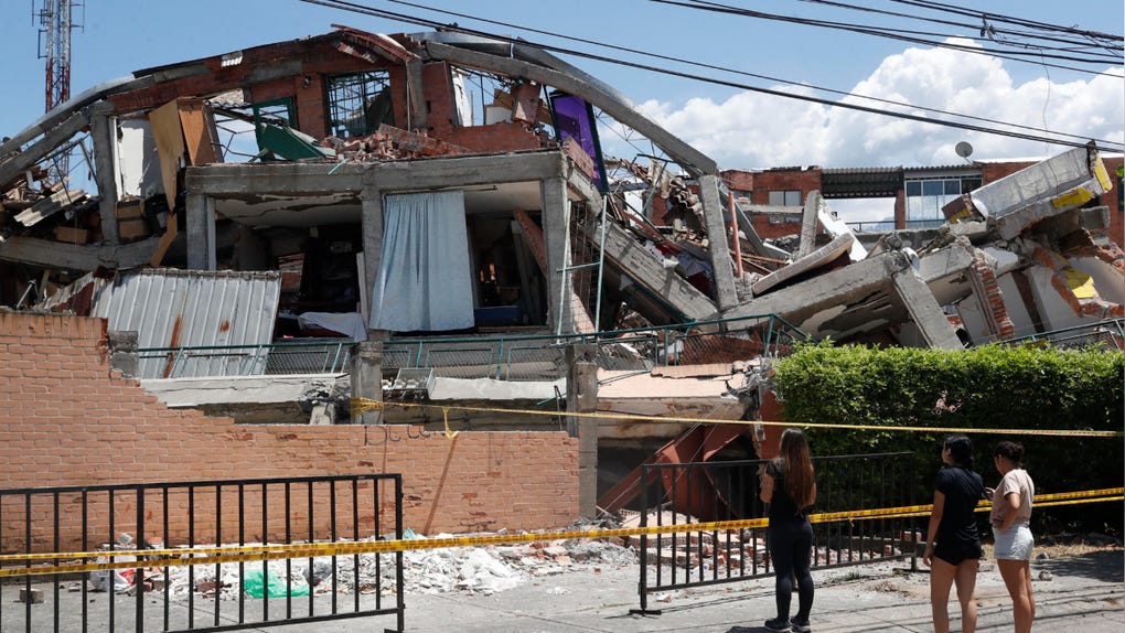 Un grupo de mujeres observa los escombros de una edificación destruida por el terremoto de magnitud 7,4 en Cali, Colombia.  