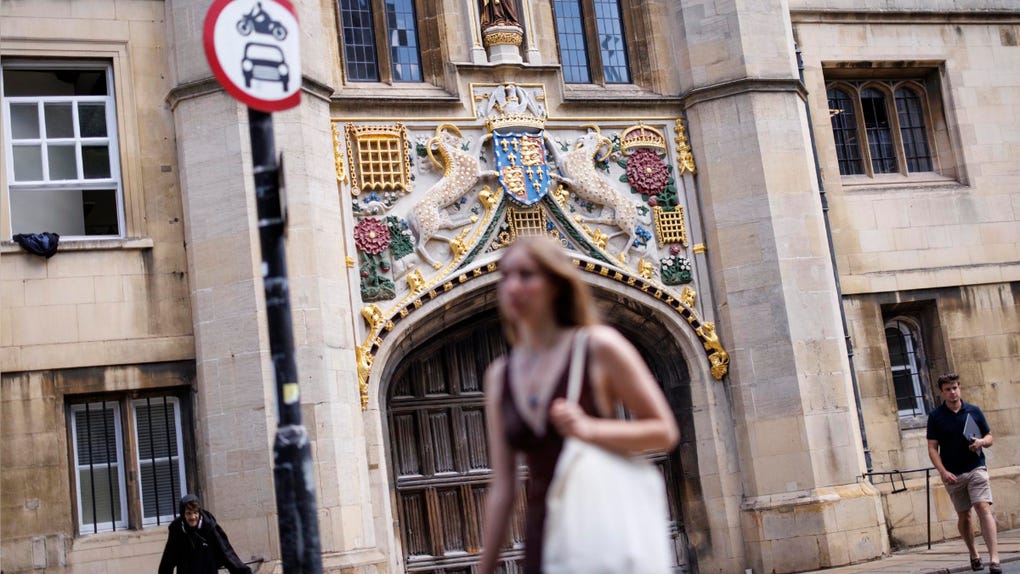 Varias personas pasan frente al Christ's College de la Universidad de Cambridge, Gran Bretaña.