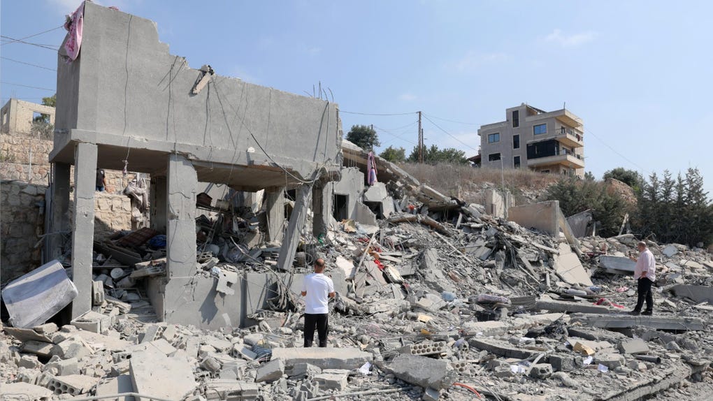 Varias personas inspeccionan un edificio dañado tras un ataque aéreo israelí en la aldea de Ansar, en el sur del Líbano.