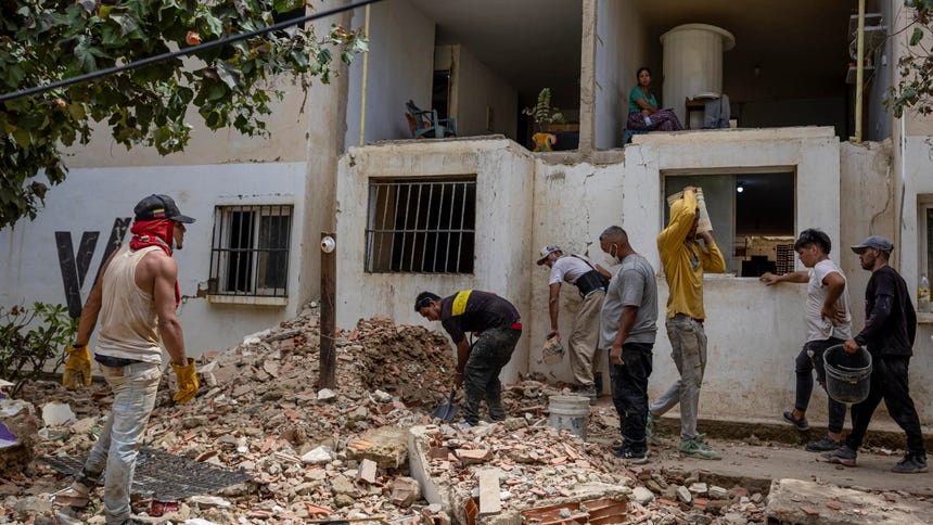 Fotografía del 17 de agosto de 2026 que muestra a personas trabajando en la reparación de un edificio afectado por los terremotos de junio, en Catia La Mar (Venezuela). 