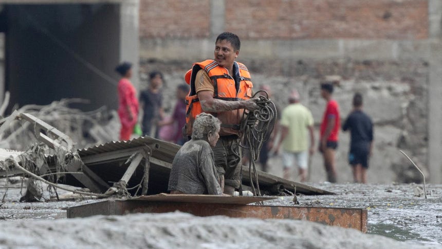 Un rescatista traslada a una mujer anciana afectada por las inundaciones en Nepal. 