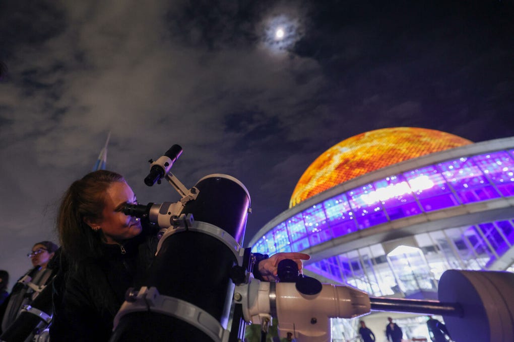 Un visitante observa a través de un telescopio la Luna durante el eclipse lunar parcial en el<strong> Planetario Galileo Galilei </strong>de <strong>Buenos Aires</strong>, <strong>Argentina</strong>.