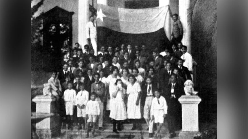 Niño y niñas peruanas posan para la foto mientras son obligados a rendir honores a los símbolos patrios de Chile (se va la bandera en la parte superior).