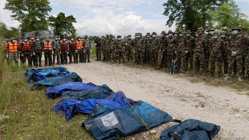 Miembros del ejercito junto a varios cuerpos recuperados a lo largo del río Narayani. 