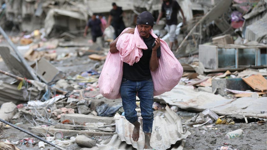 Un hombre recolecciona todo los bienes que pudo rescatar a una comunidad afectada por la riada que ocurrió en la frontera entre China y Nepal.