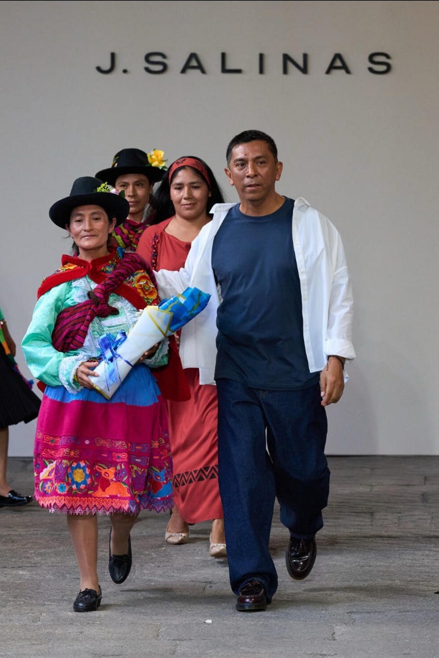 Jorge Luis Salinas junto a las artesanas peruanas con las que trabaja en su taller en Gamarra al cierre de su desfile en Milán.