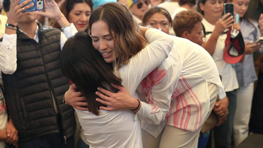 Claudia Macero (c-d), jefa de comunicaciones de la líder de la oposición y premio nobel de la paz María Corina Machado, abraza a una seguidora en una rueda de prensa este lunes, en Caracas (Venezuela).