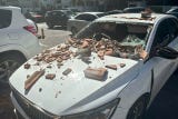 Un vehículo lució afectado por restos de un edificio tras el terremoto de magnitud 7,7.