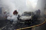<strong>Bomberos</strong> intervienen para sofocar el incendio de un vehículo durante una manifestación en <strong>París</strong> contra el aumento del coste de la vida y los recortes en los servicios públicos.