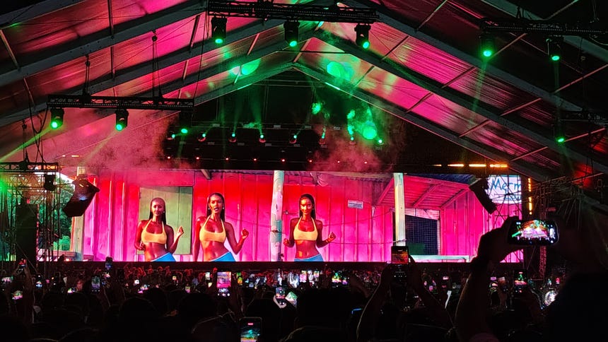 La propuesta visual de Hugel se caracteriza por una estética colorida, con bailarinas y coreografías que invitan al público a sumarse a la fiesta.