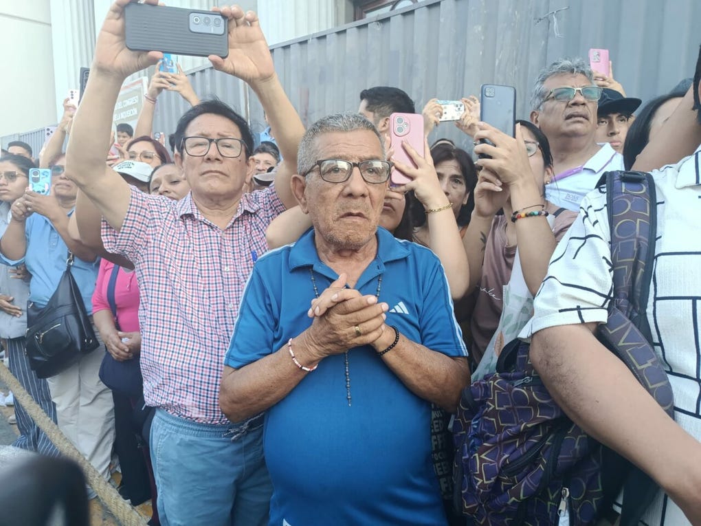 Devotos del Señor de Los Milagros ven el paso de la imagen en el Centro de Lima.